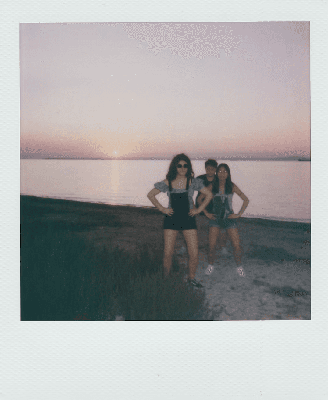 Friends posing together on the shore at sunset