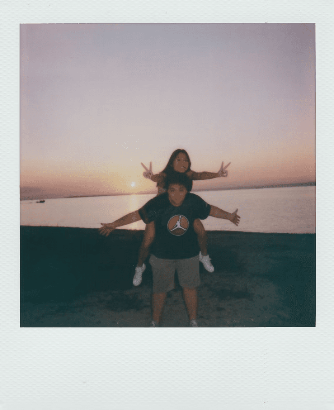 Two friends celebrating on the beach at sunset